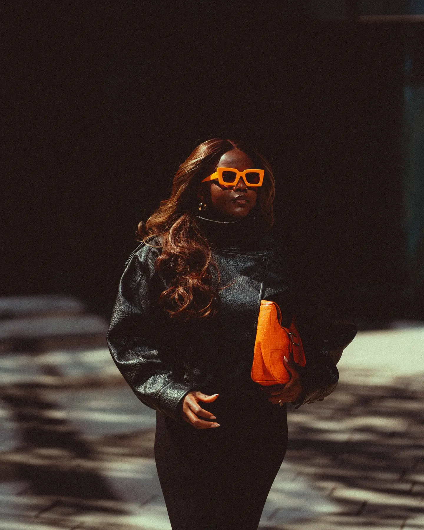 Fashion-Portrait in Schwarz mit markanten orangefarbenen Accessoires